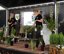 Anna Nilsson och Martina Illerhag från Kiviks trädgård föreläser på en scen med växter.